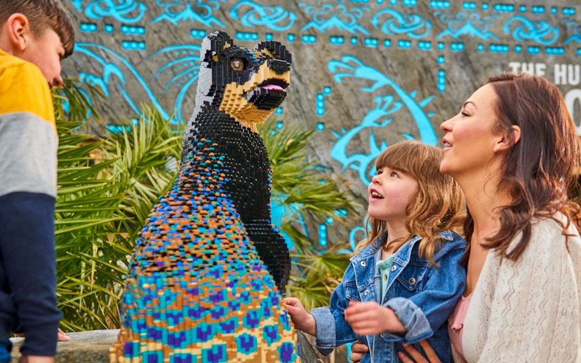 Child and adult admiring LEGO sculpture at LEGOLAND Windsor Resort.
