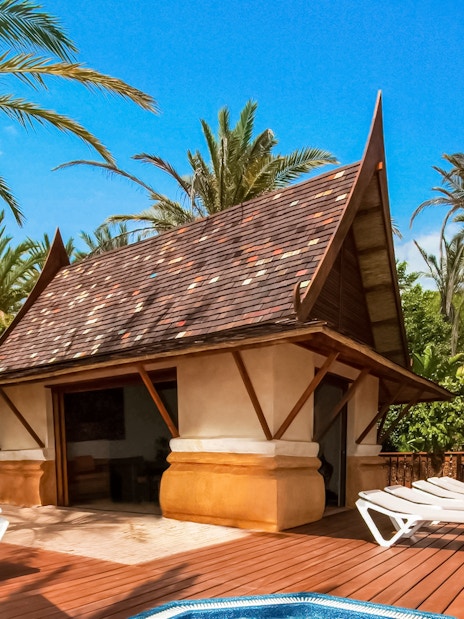 Cabana with loungers at Siam Park surrounded by palm trees.