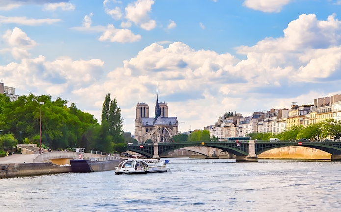 Seine River cruise boat near Notre-Dame Cathedral, Paris.