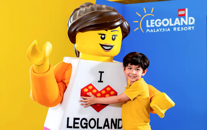 Child embracing LEGO character at Legoland Malaysia Resort.