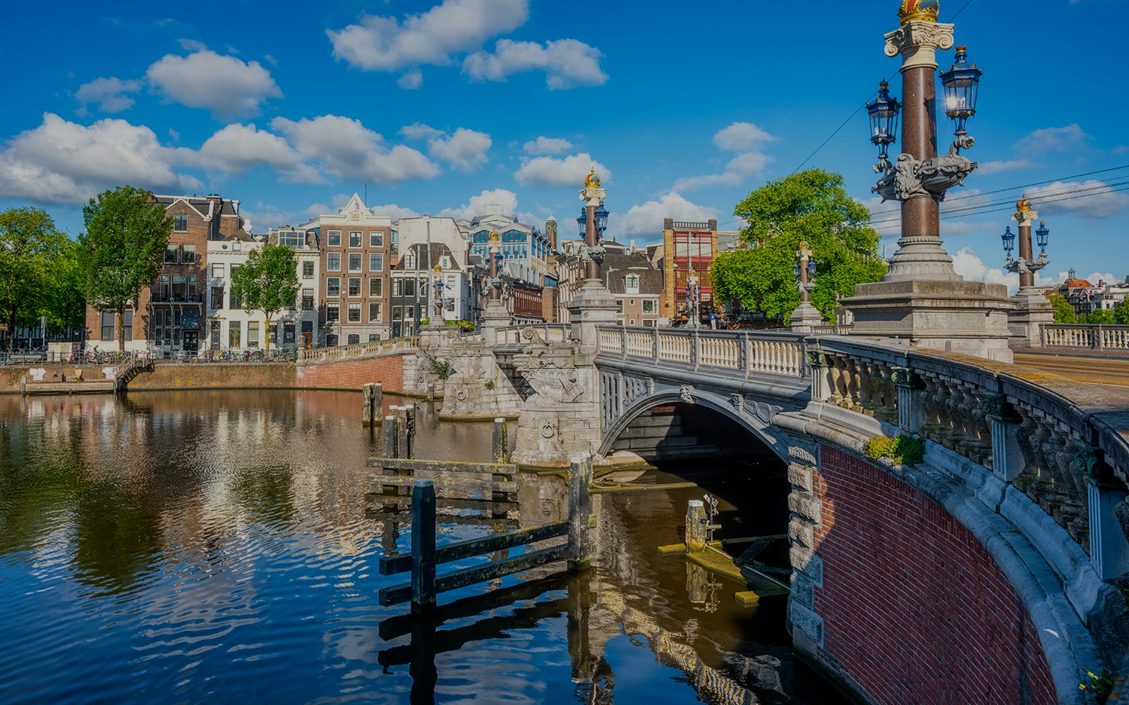 Bridge over canal with historic buildings in Amsterdam, Netherlands.