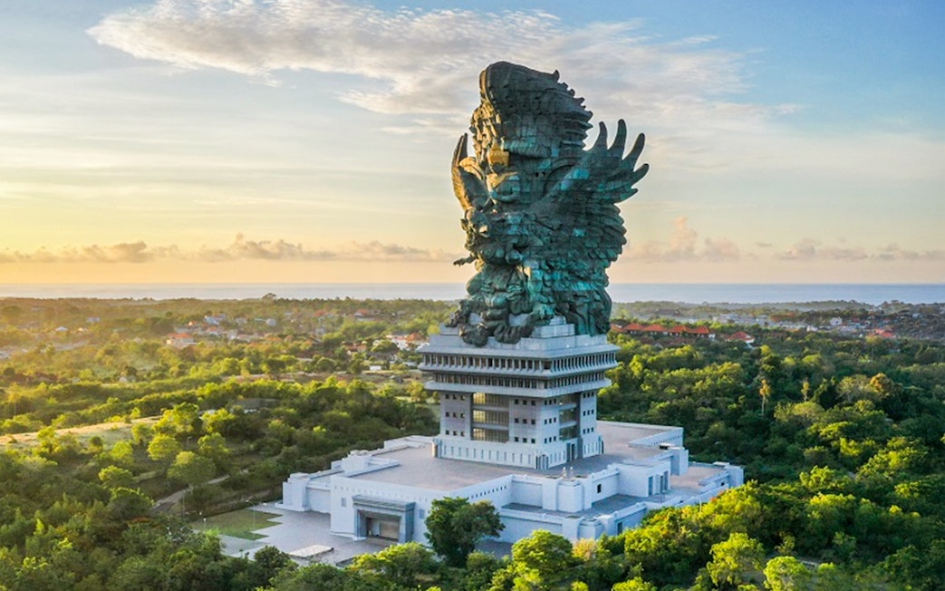 Garuda Wisnu Kencana statue in Bali, Indonesia, surrounded by lush greenery.