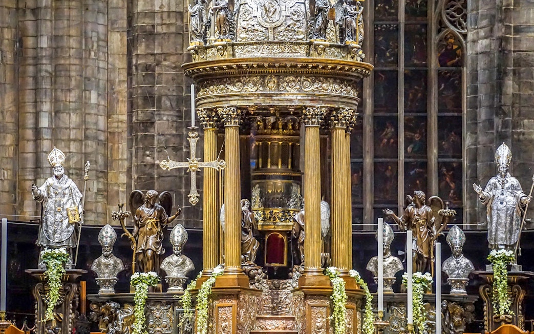 Duomo Milan Cathedral interior with ornate altar and religious statues.