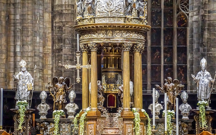 Duomo Milan Cathedral interior with ornate altar and religious statues.