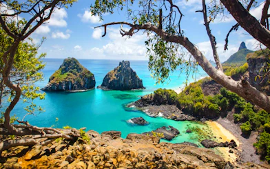 Noronha coast view with turquoise waters and rocky islets, seen from a cliff, Sao Paulo.