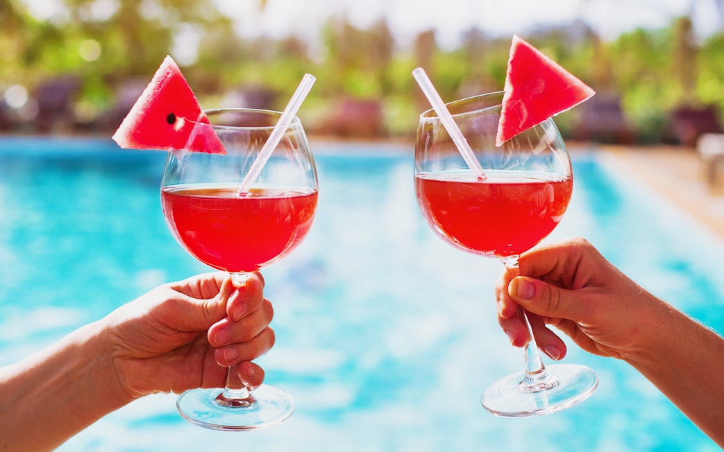 Tourists holding drinks by the thermal pool at Therme Bucuresti Spa, Bucharest.