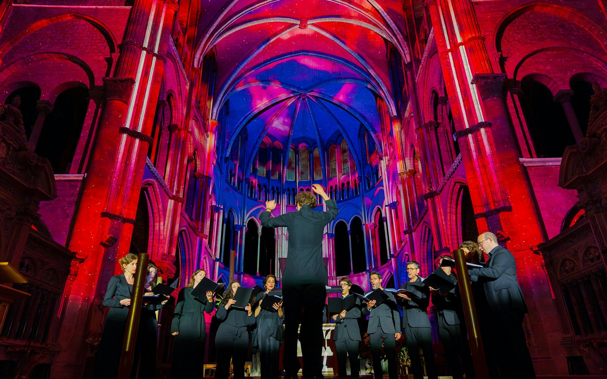 Choir performing under colorful lights at Manchester Cathedral during LUMINISCENCE 360° Immersive Show.