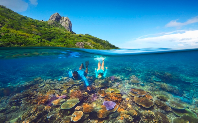Snorkeling over coral reefs with marine biologist at Kuata Island, Fiji.