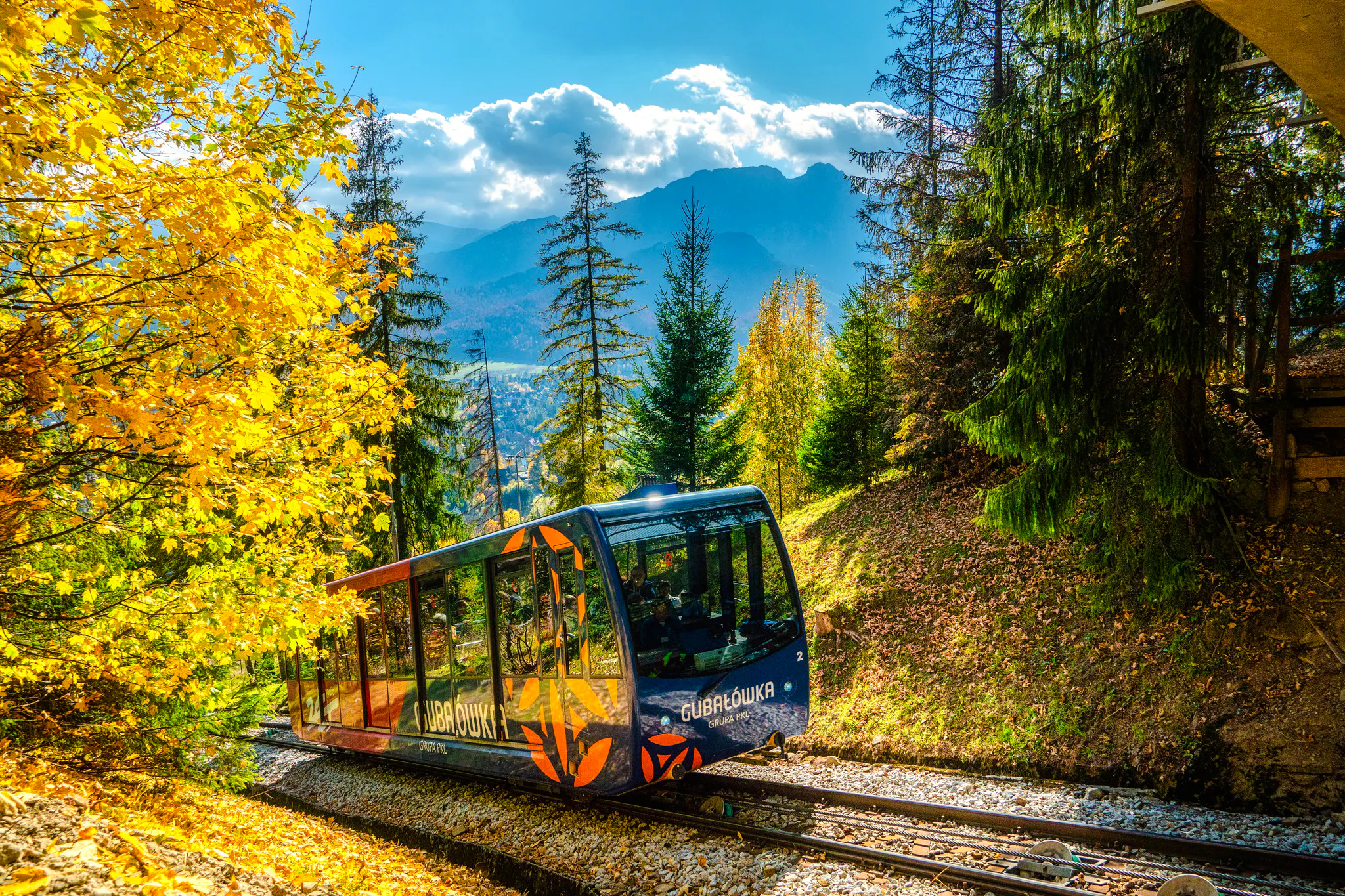 Cable car ascending through autumn forest in Zakopane during private day trip from Krakow.