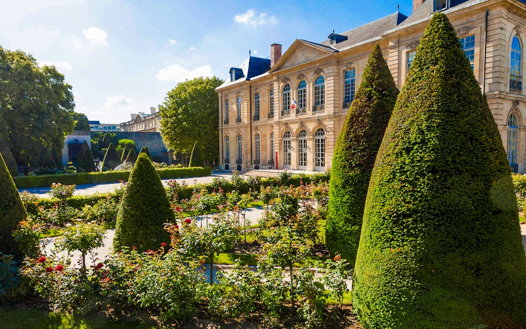 Rodin Museum Gardens with manicured hedges and historic building in Paris.