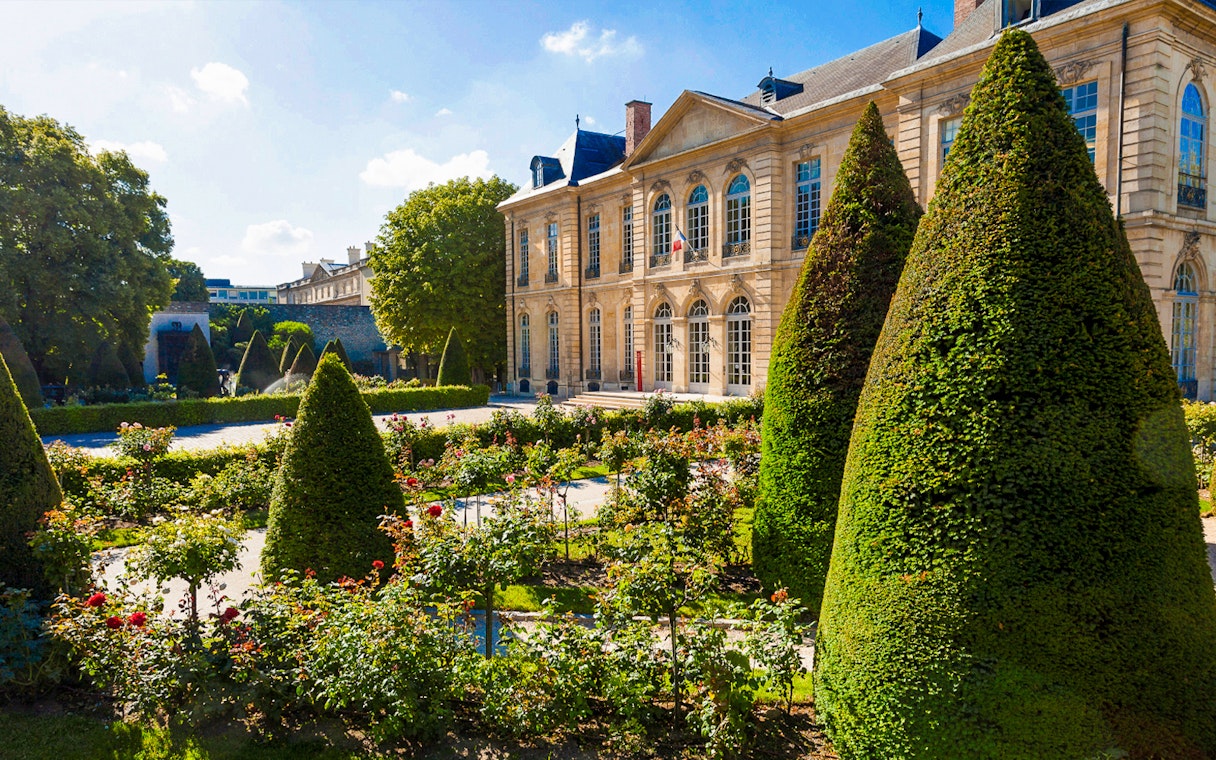Rodin Museum Gardens with manicured hedges and historic building in Paris.