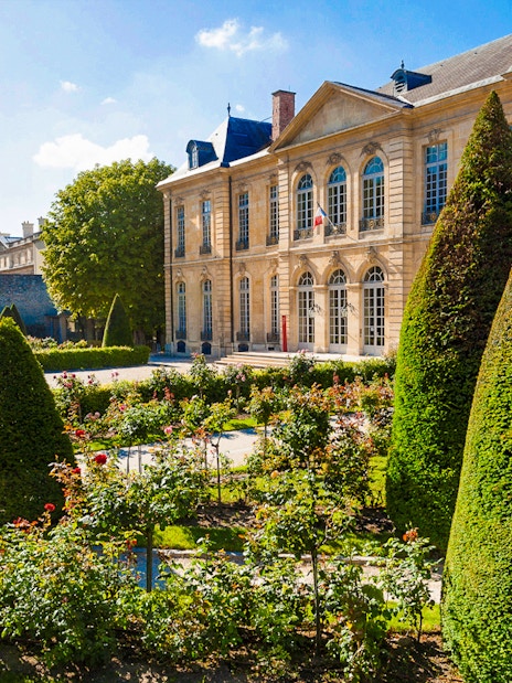 Rodin Museum Gardens with manicured hedges and historic building in Paris.