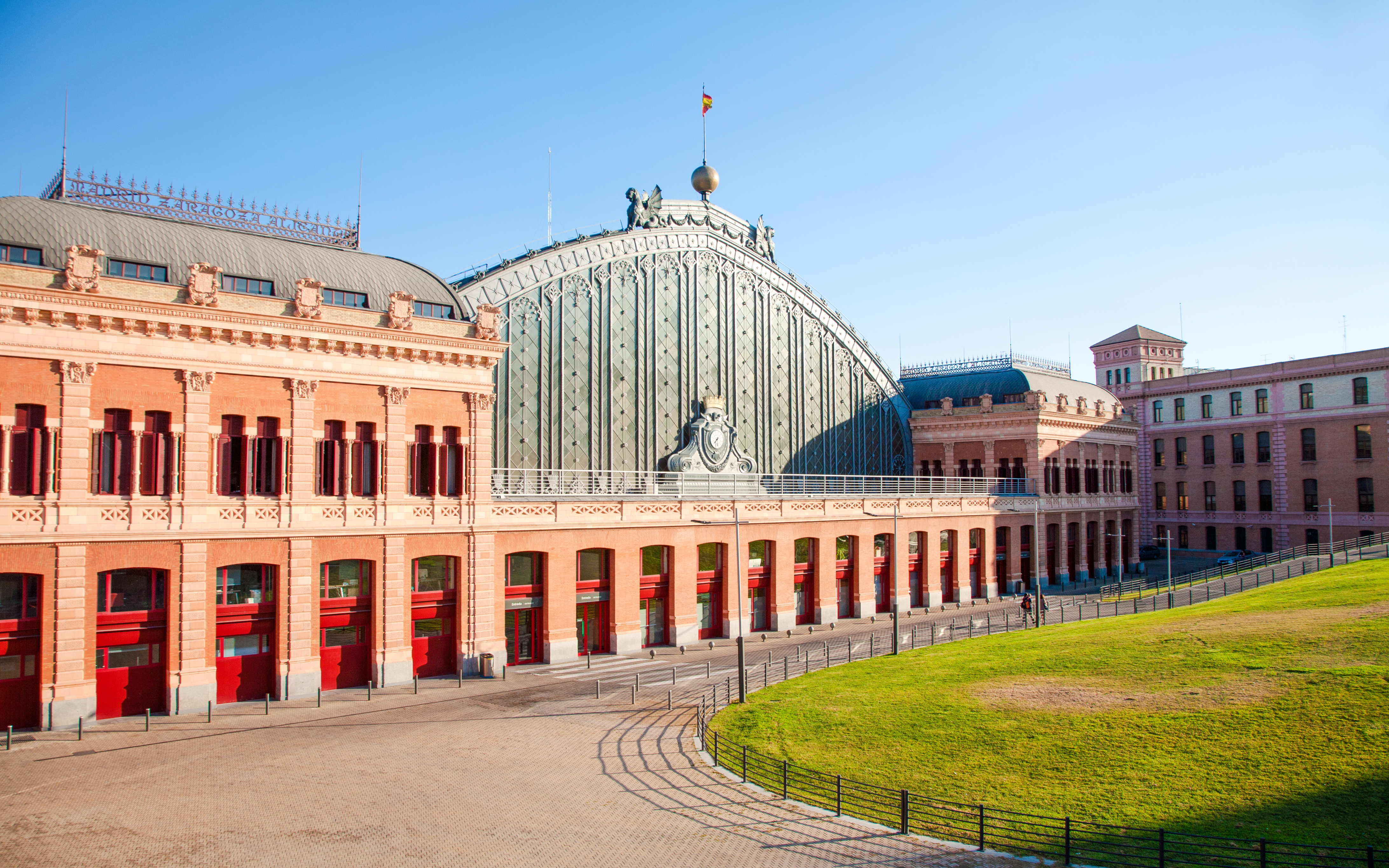 Facade of Madrid Atocha train station with red brick and arched windows, Madrid.