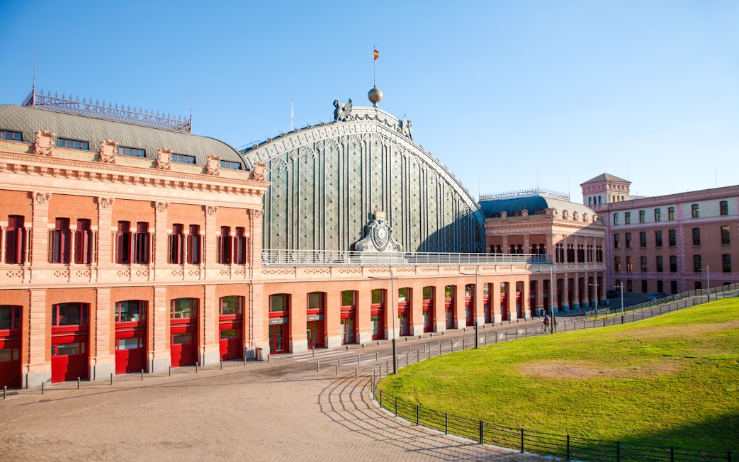 Facade of Madrid Atocha train station with red brick and arched windows, Madrid.
