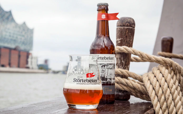 Störtebeker beer bottle and glass with Elbphilharmonie in background, Hamburg, Germany.