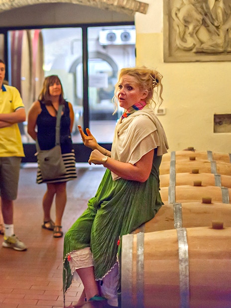 Group listening to a guide in a Chianti wine cellar during a wine and olive oil tour.