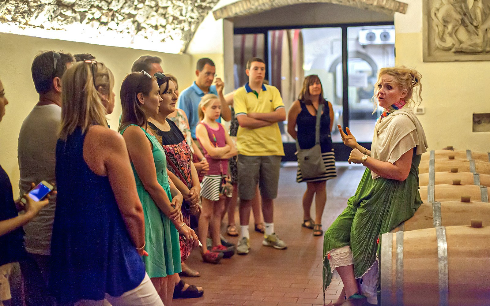Group listening to a guide in a Chianti wine cellar during a wine and olive oil tour.