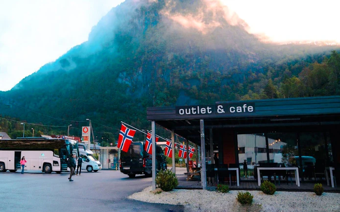 Cafe with Norwegian flags near mountains during Viking Village day trip.