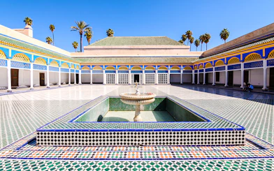 Bahia Palace courtyard with fountain and colorful tilework in Marrakech, Morocco.