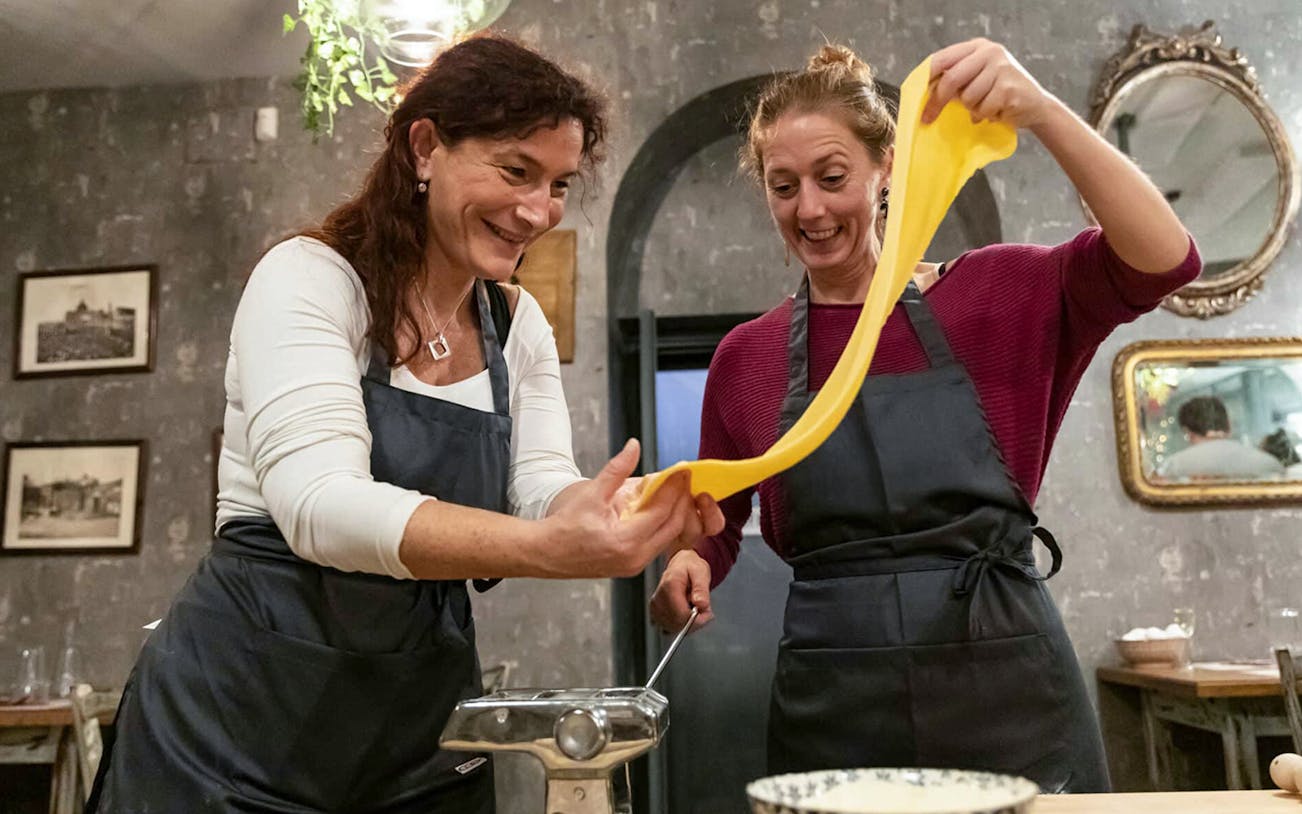 Participants making fettuccine in a pasta class in Trastevere, Rome.