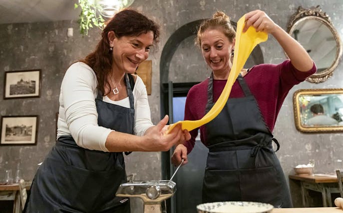 Participants making fettuccine in a pasta class in Trastevere, Rome.