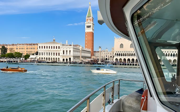 Boat approaching St. Mark's Square in Venice with view of Campanile and Doge's Palace.