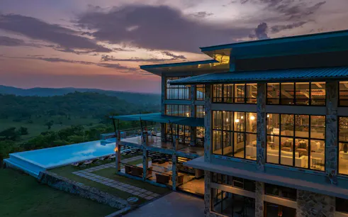 Lodge with infinity pool overlooking Mikumi National Park at sunset, part of 2-day safari from Zanzibar.