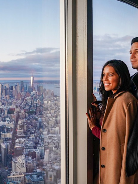 Couple enjoying New York City skyline view from Empire State Building Observatory.