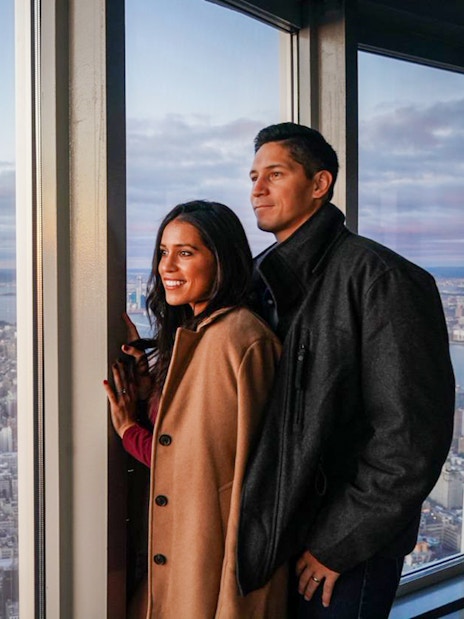 Couple enjoying New York City skyline view from Empire State Building Observatory.