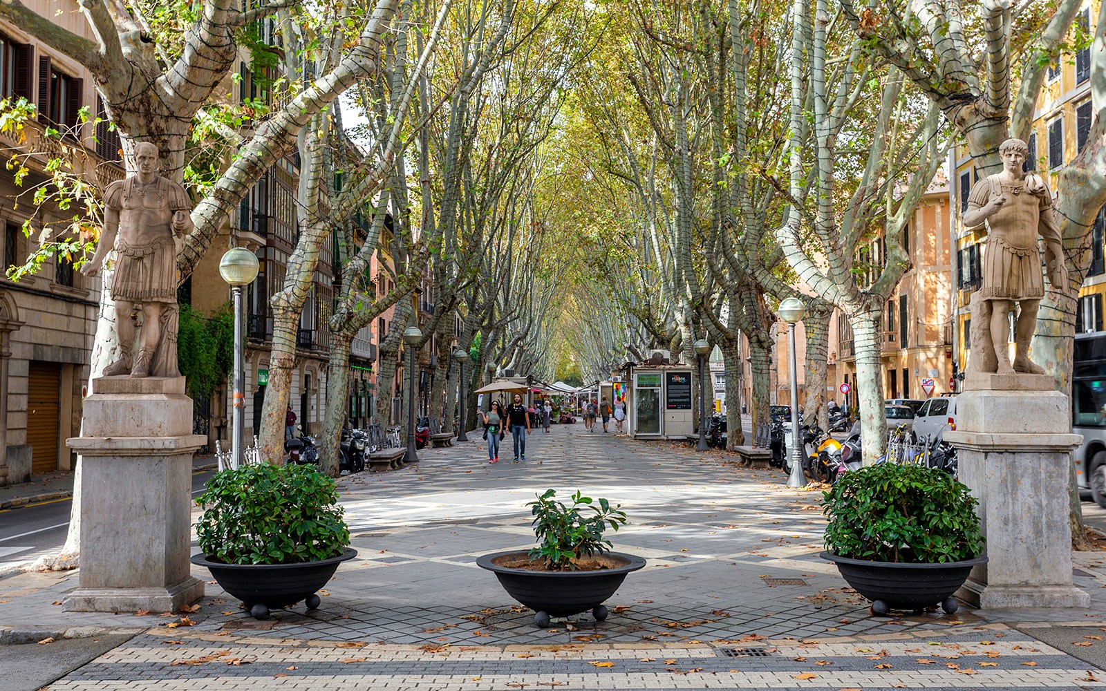 La Rambla street view with vibrant market stalls and pedestrians in Mallorca.