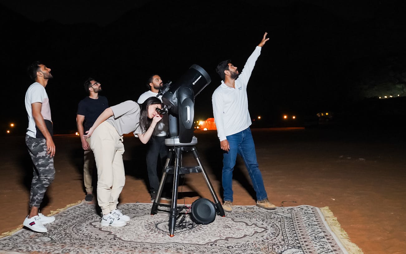 Group stargazing with telescope at Mleiha Space Camp, UAE.