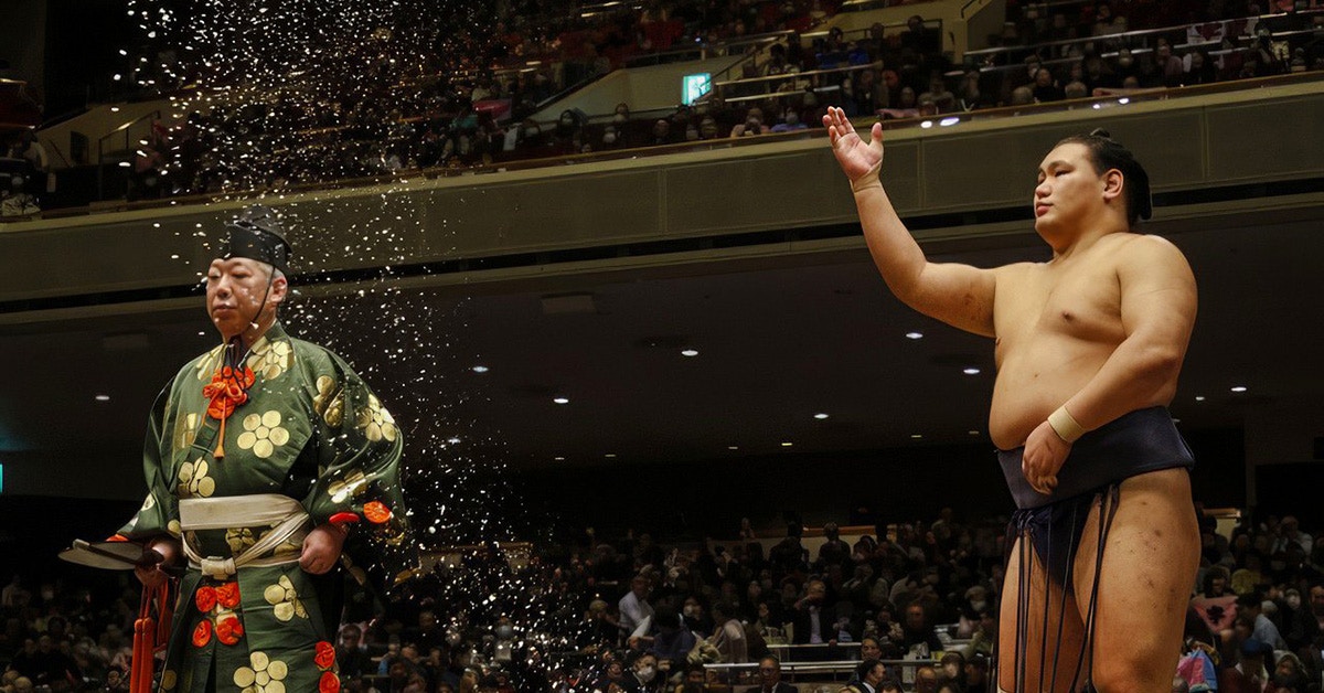 Sumo wrestler tossing salt during a traditional ceremony in Japan.