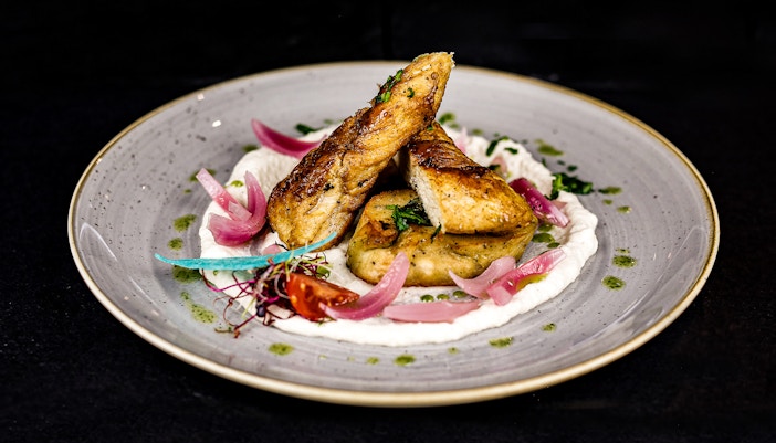 Chicken breast, bread dumpling with spinach and pickled red onion on new york lunch Dinner Cruise