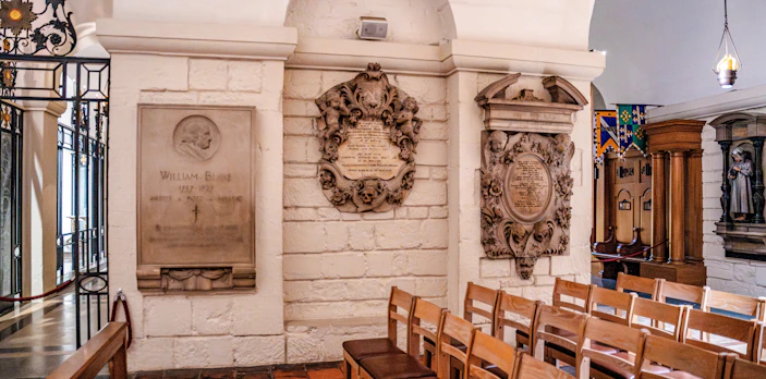 Crypt interior of St Paul's Cathedral with memorial plaques and seating.