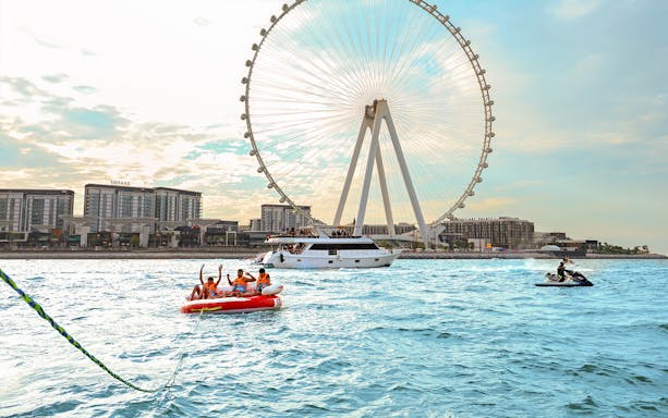 Donut ride on water near Ferris wheel in Dubai.