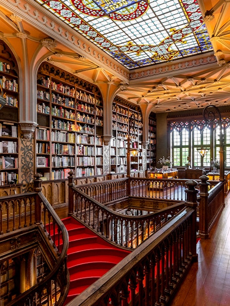 Lello Library first floor with ornate wooden staircase and stained glass ceiling.