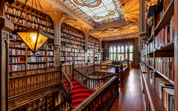 Lello Library first floor with ornate wooden staircase and stained glass ceiling.