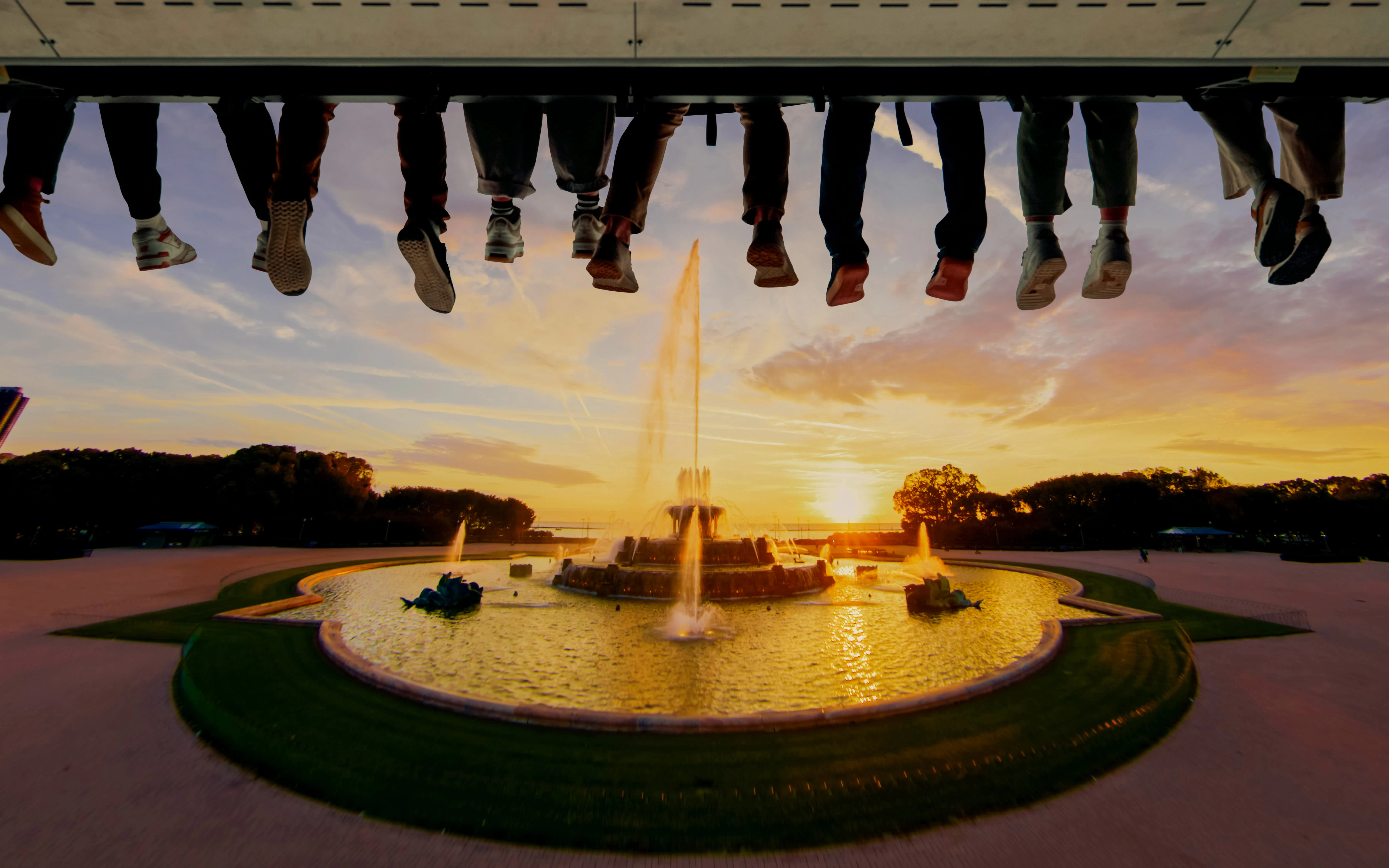 Visitors enjoying Flyover Chicago experience above Buckingham Fountain at sunset.