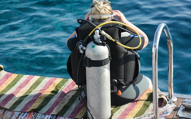 Snorkeler preparing to dive from boat in Hurghada during full-day tour.