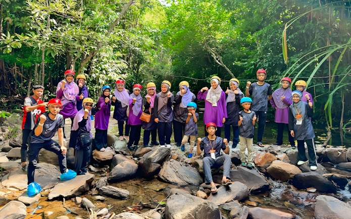 Group of people in helmets posing on rocks during Langkawi Sky ATV Ride at Mountain Manchinchang.