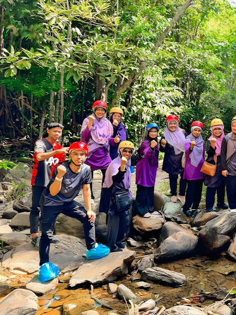 Group of people in helmets posing on rocks during Langkawi Sky ATV Ride at Mountain Manchinchang.