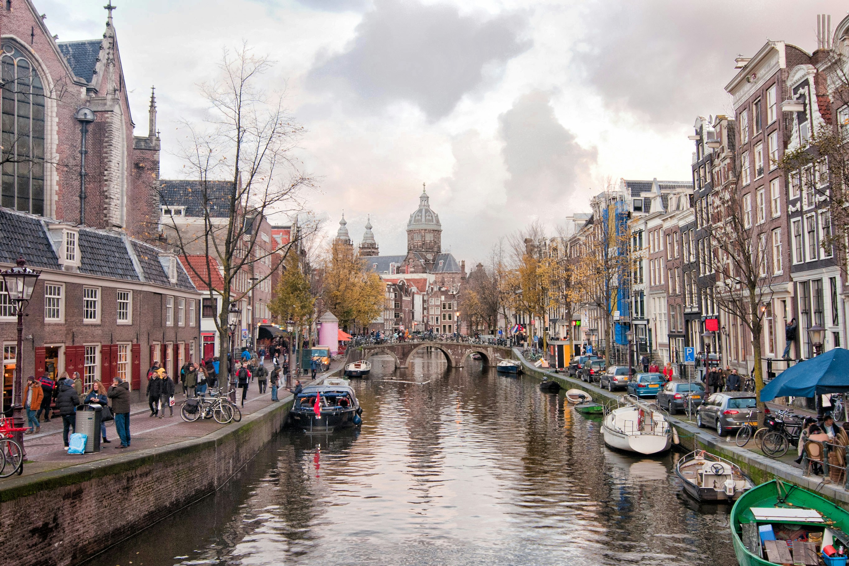 Oudezijds Voorburgwal canal with boats and historic buildings in Amsterdam.