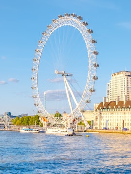 London Eye overlooking the Thames River at sunset.