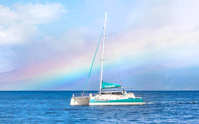 Sailboat on a Luxury West Snorkel Sail Tour in Maui, Hawaii with a rainbow in the background.