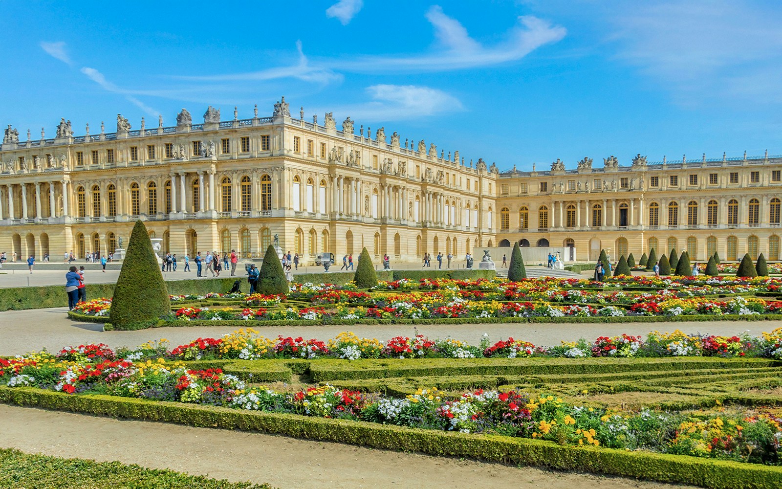 Palace of Versailles with ornate architecture and expansive gardens in France.