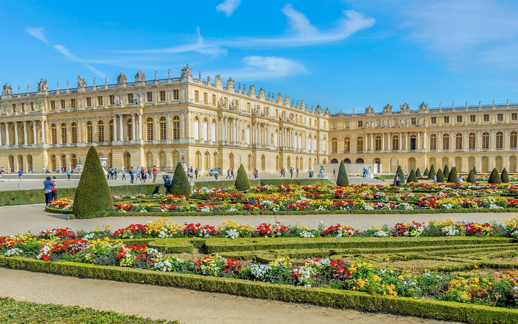 Palace of Versailles with ornate architecture and expansive gardens in France.