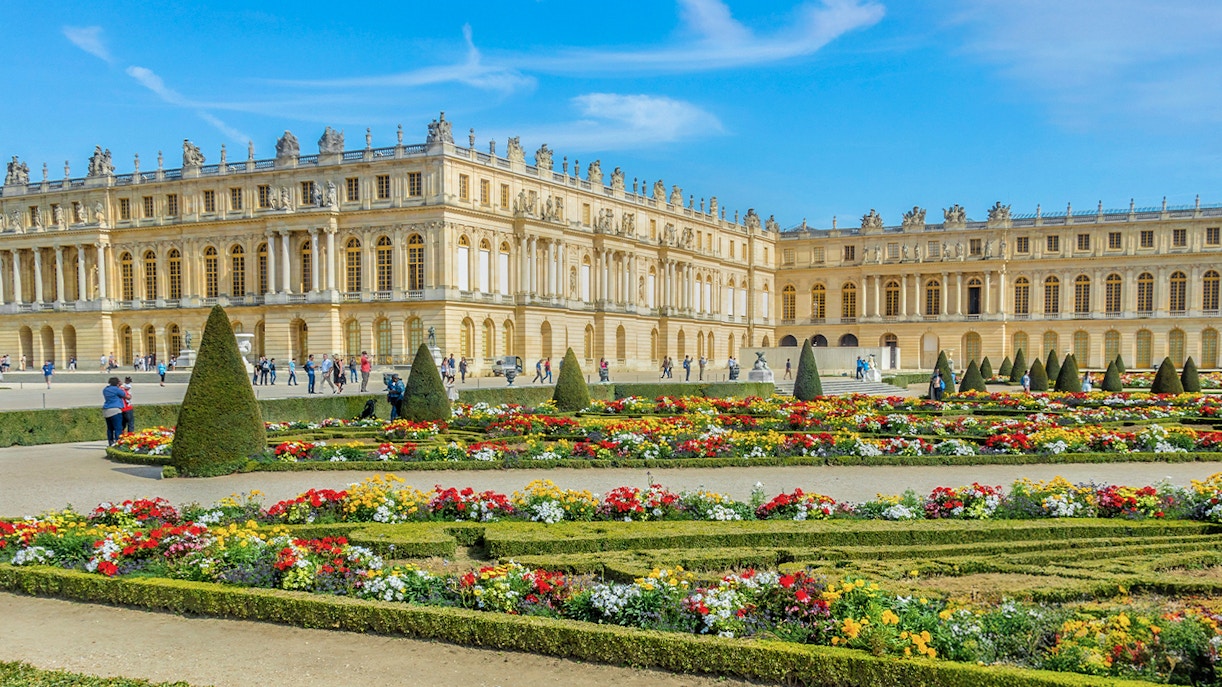 Palace of Versailles with ornate architecture and expansive gardens in France.