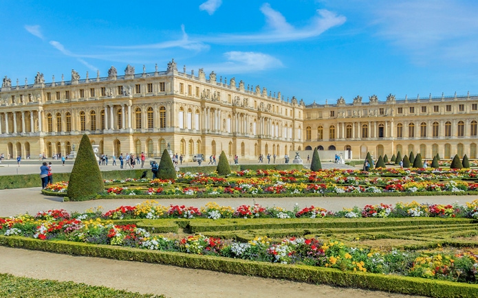 Palace of Versailles with ornate architecture and expansive gardens in France.