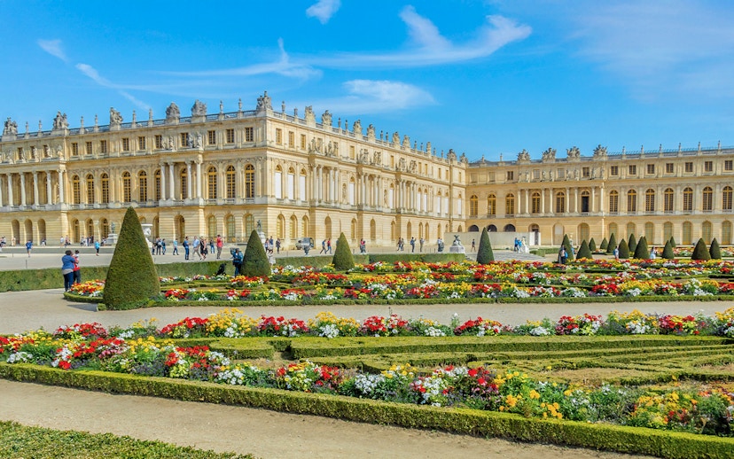 Palace of Versailles with ornate architecture and expansive gardens in France.