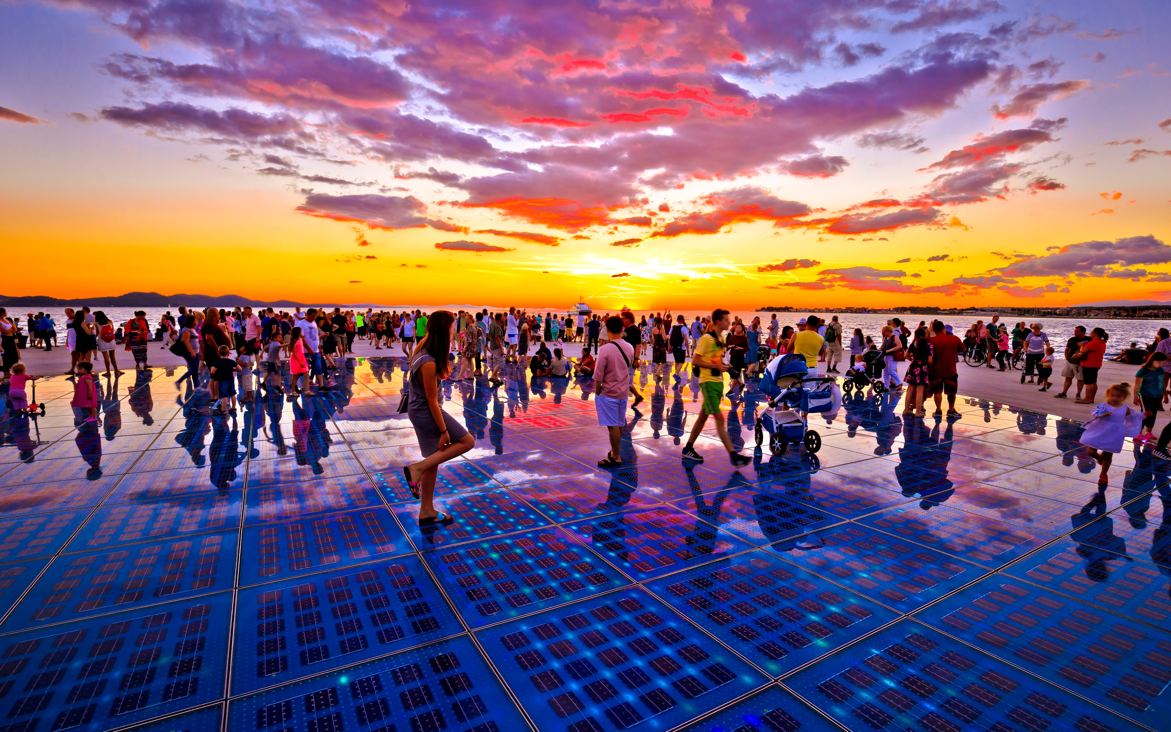 Crowd enjoying sunset at Sun installation, Zadar, Croatia.